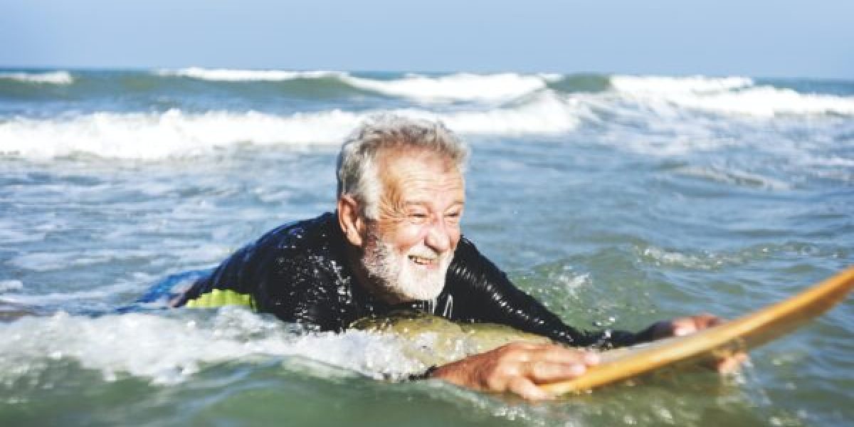 A senior man on a surfboard